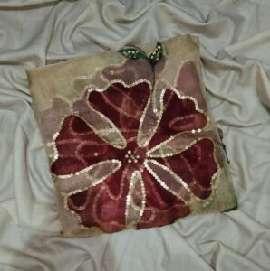 Light skin organza dupatta with hand-painted red and pink floral designs, decorated with gold detailing and beads.